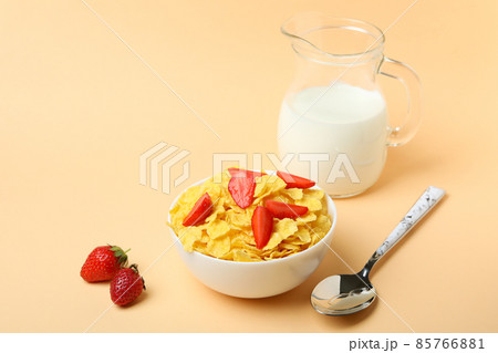 Concept of tasty breakfast with cornflakes on beige background Concept of tasty breakfast with cornflakes on beige background 85766881