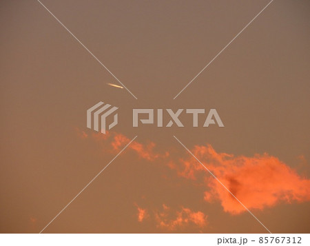 夕陽に赤く染まる雲と飛行機雲 夕陽に赤く染まる雲と飛行機雲 85767312