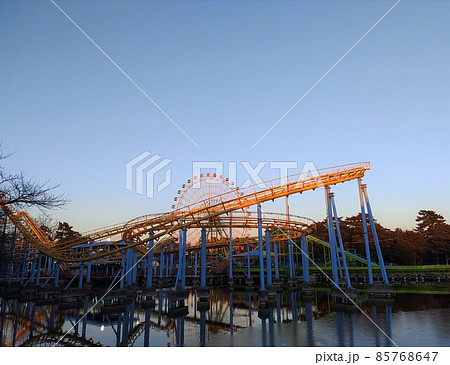 冬の夕暮れの凍った池と遊園地のジェットコースター 伊勢崎市 の写真素材