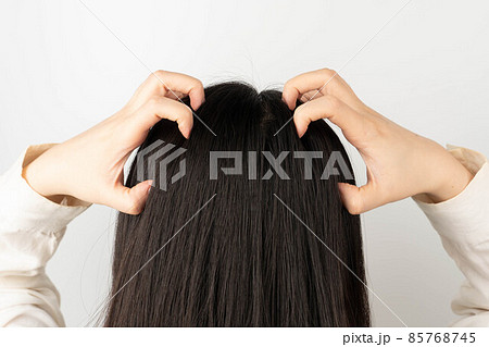 Woman scratching her head because of an itchy scalp. Causes of itchy includes dandruff, seborrheic dermatitis, psoriasis, Tinea capitis or allergy to hair care products. Woman scratching her head because of an itchy scalp. Causes of itchy includes dandruff, seborrheic dermatitis, psoriasis, Tinea capitis or allergy to hair care products. 85768745