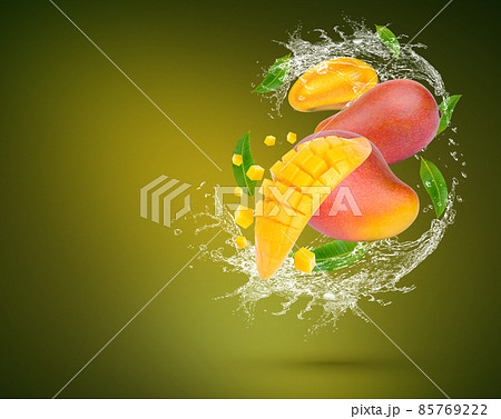Water Splash on fresh mango with leaves Isolated on green Background Water Splash on fresh mango with leaves Isolated on green Background 85769222