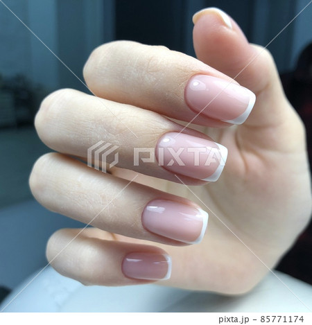French manicure on the nails.Manicure gel nail polish. Spa and Manicure concept. Female hands with french manicure. 85771174