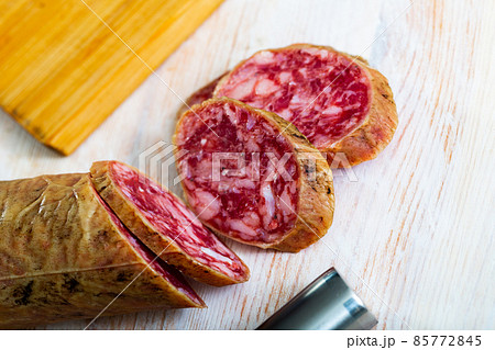 Appetizing salchichon sausage on wooden table 85772845