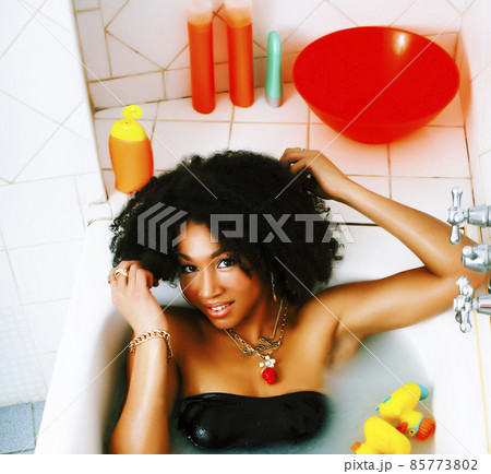 young african american teen girl laying in bath with foam, wearing swag jewelry flawless, making selfie young african american teen girl laying in bath with foam, wearing swag jewelry flawless, making selfie 85773802
