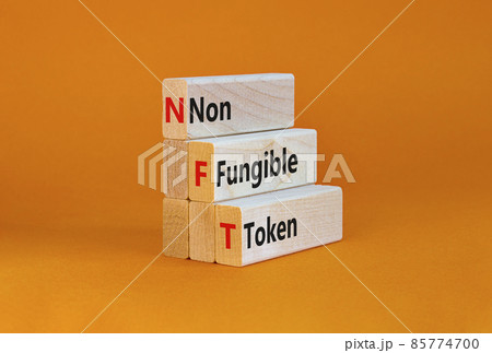 NFT non-fungible token symbol. Concept words NFT non-fungible token on wooden blocks. Beautiful orange table, orange background, copy space. Business and NFT non-fungible token concept. 85774700