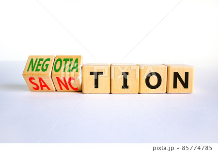 Sanction or negotiation symbol. Turned wooden cubes and changed the word sanction to negotiation. Beautiful white table, white background, copy space. Business, sanction or negotiation concept. 85774785