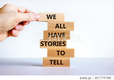 We all have stories to tell symbol. Wooden blocks with words 'We all have stories to tell'. Businessman hand. Beautiful white background. Business, popular quotation concept. Copy space. 85774786