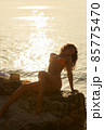 Beach Girl Model in Orange Bikini on the Rocky Deserted Seashore During Summer Beach Holidays 85775470