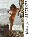 Beach Girl Model in Orange Bikini on the Rocky Deserted Seashore During Summer Beach Holidays 85775477