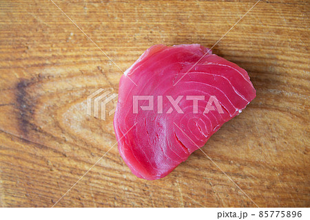 Raw tuna steak on a wooden board, top view. Delicious and healthy food for the body. 85775896