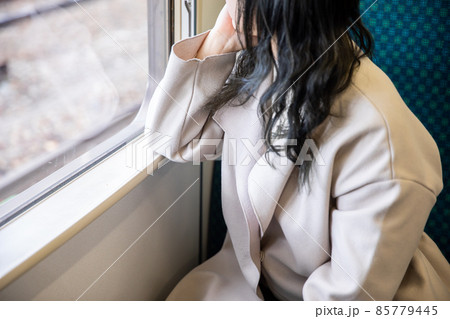 車窓から外を眺める女性　Cheek cane 85779445