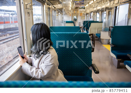 車窓から外を眺める女性　Cheek cane 85779451