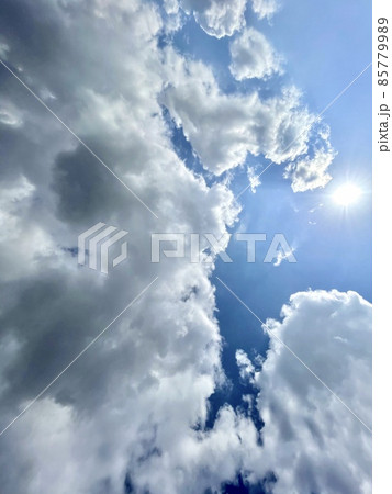 青空に浮かぶ大きな雲と太陽 85779989