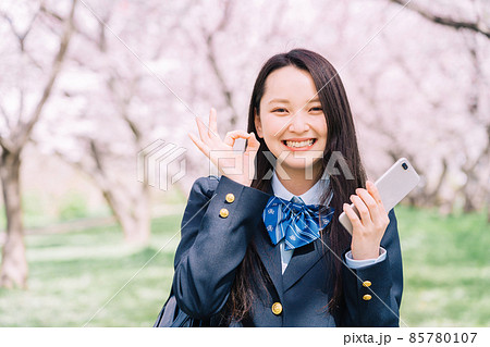 桜の木の下でスマホを持ってオッケーサインをする高校生 桜の木の下でスマホを持ってオッケーサインをする高校生 85780107