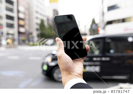 スマートフォンを持った若い男性の手元 85781747