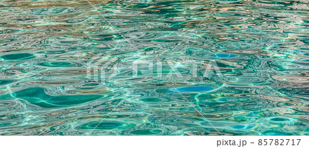 Emerald sea water in sunshine glow as surface background. Summer holidays concept 85782717