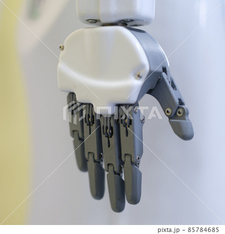 Metal robot hand on a gray background, close-up Metal robot hand on a gray background, close-up 85784685