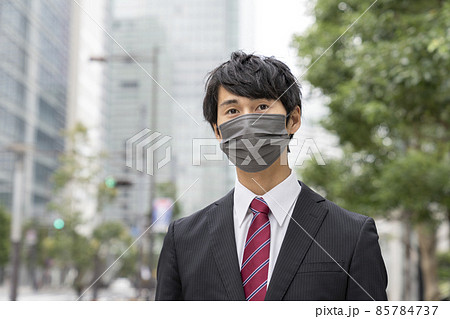 グレーの不織布マスクをした若いビジネスマン 85784737