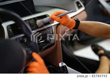 Hands brush dust from the ventilation system in the car 85784743