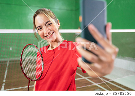 Asian female badminton player selfie with a smartphone Asian female badminton player selfie with a smartphone 85785556