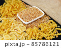 some dry wheat and different shapes of pasta standing on black background,close-up of macaroni and wheat together, 85786121