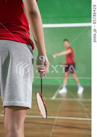 A badminton player's hand holding a racket while playing badminton 85786429