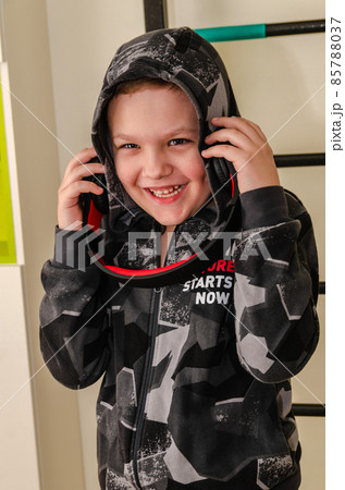 A little boy listens to music in wireless headphones at home. 85788037