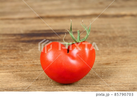Ripe tomato in a shape of heart. 85790703