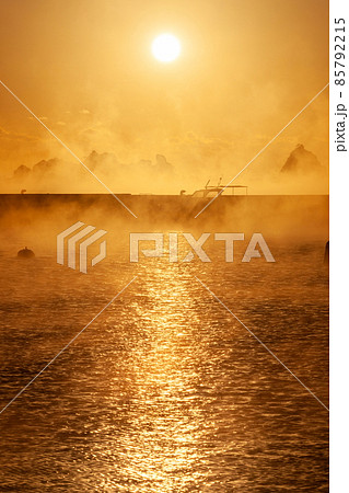 太平洋日向灘に昇る日出で黄昏色に染まった日南海岸の南郷町外ノ浦港に立ち昇る毛嵐 85792215