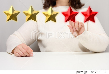Customer experience feedback concept. Five red stars, the best rating of excellent services with a female hand to meet. White table 85793089