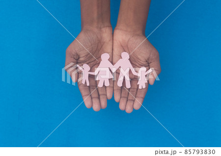 Hand holding family figure cutout top view. World health day Protection against domestic violence, healthcare and medical background. Foster care, homeless support and social distancing concept. 85793830