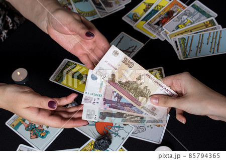 Moscow,Russia November 22.19. Hands holding cash Rubles on the background of wallet and Tarot cards. Payment for esoteric, magical and witchcraft services in Russia is made in national currency rubles 85794365