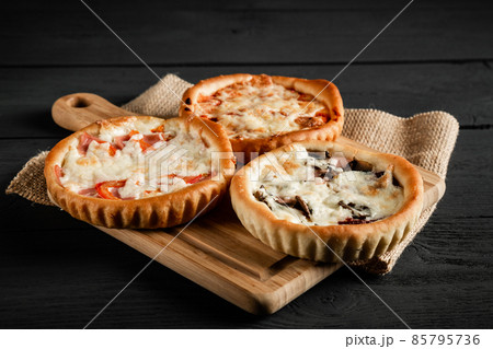 Delicious pizza on a black wooden background. Rustic style. With a copy space. 85795736
