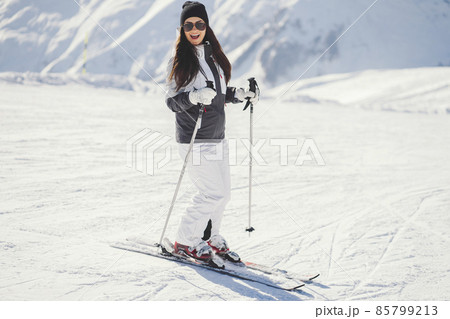 young and active brunette skiing in the snowy mountains 85799213
