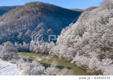 Mountain river stream in winter. Amazing winter forest at sunny day aerial view 85800420