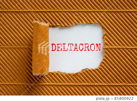 Covid-19 corona deltacron symbol. The concept word Deltacron appearing behind torn brown paper. Beautiful brown and white background. Medical, covid-19 corona deltacron variant concept. Copy space. 85800922