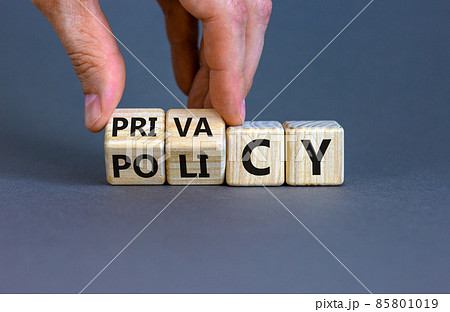 Privacy policy symbol. Hand turns the wooden cube with words 'Privacy policy' on a beautiful grey background. Business and privacy policy concept. Copy space. 85801019