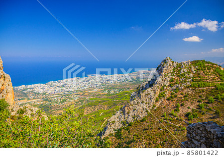 Aerial view of Kyrenia Girne mountain range and valley in front of Mediterranean sea, green trees on rock foreground 85801422