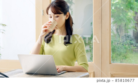 カフェでノートパソコンを使って仕事をする女性 85810677