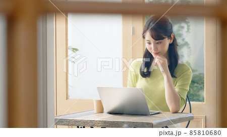 カフェでノートパソコンを使って仕事をする女性 85810680