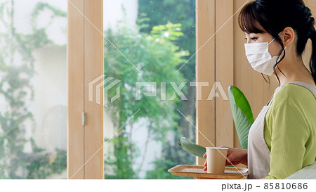 マスクをして接客するカフェ店員 85810686