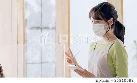 注文を取る女性店員 85810688