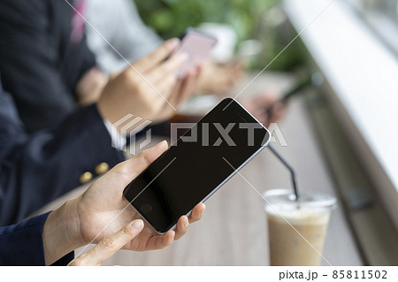 スマートフォンを持った女性の手元（ホームボタン有り） 85811502