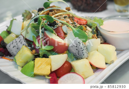 Plate with colorful mixed vegetables and fruit salad with dressings. Plate with colorful mixed vegetables and fruit salad with dressings. 85812930
