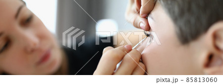 Woman stylist paints eyes of client close-up 85813060