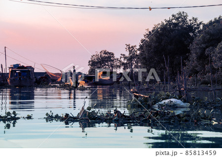 Silhouette of a fisherman casting a fishing net in the Mekong Delta showing the life and culture of the Vietnamese people Silhouette of a fisherman casting a fishing net in the Mekong Delta showing the life and culture of the Vietnamese people 85813459