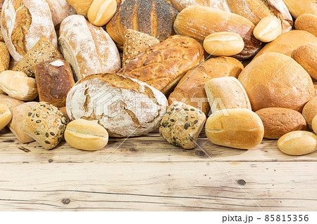 Many kinds and kinds of bread collected in one place on a wooden old shop counter as a decoration for a traditional bakery. White background from the top for self-completion. 85815356