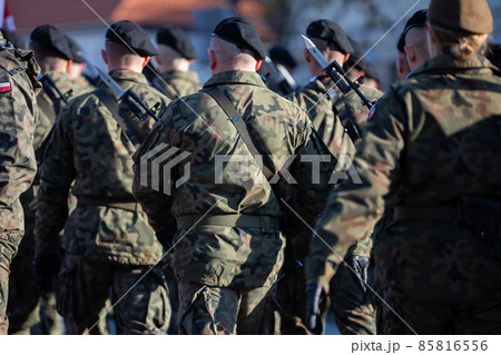 Young soldiers in black berets with guns and bayonets holstered. 85816556
