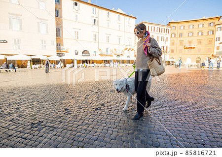 Woman walks with italian shepherd dog on Navona square in Rome Woman walks with italian shepherd dog on Navona square in Rome 85816721