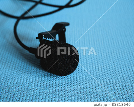 Lavalier microphone on a blue background, close-up. A lavalier microphone or lavalier is a small microphone used for television, theater, and public speaking. Lavalier microphone on a blue background, close-up. A lavalier microphone or lavalier is a small microphone used for television, theater, and public speaking. 85818646